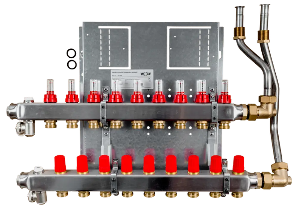 Heizkreisverteiler mit mehreren Durchflussmessern, ausgestattet mit roten Ventilkappen und Metallanschlüssen. Das Produkt stammt von der Marke Wolf.